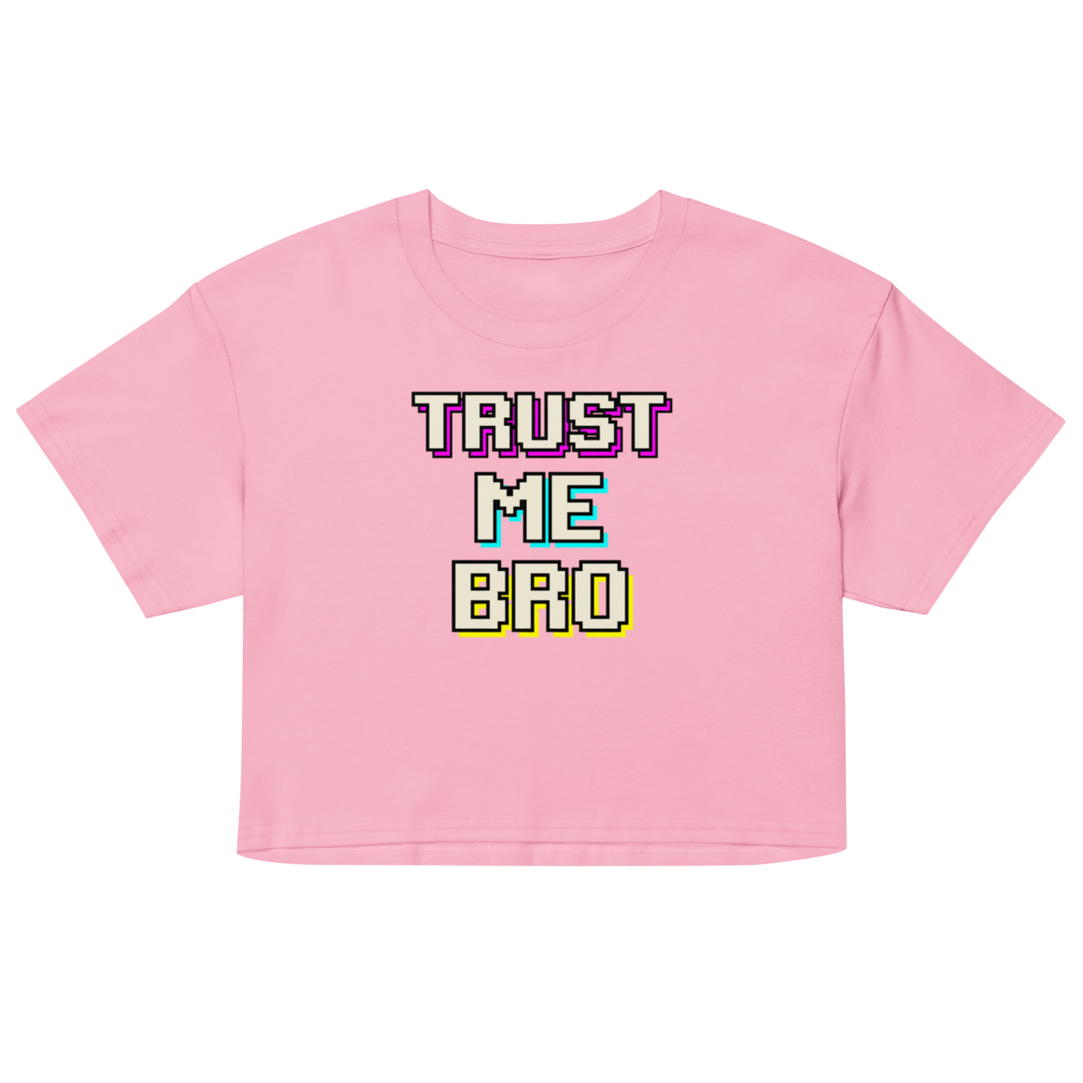 A pink short-sleeve crop top t-shirt featuring a retro pixelated graphic that reads 'TRUST ME BRO' in white, purple, teal, and yellow block letters with glitch effects.