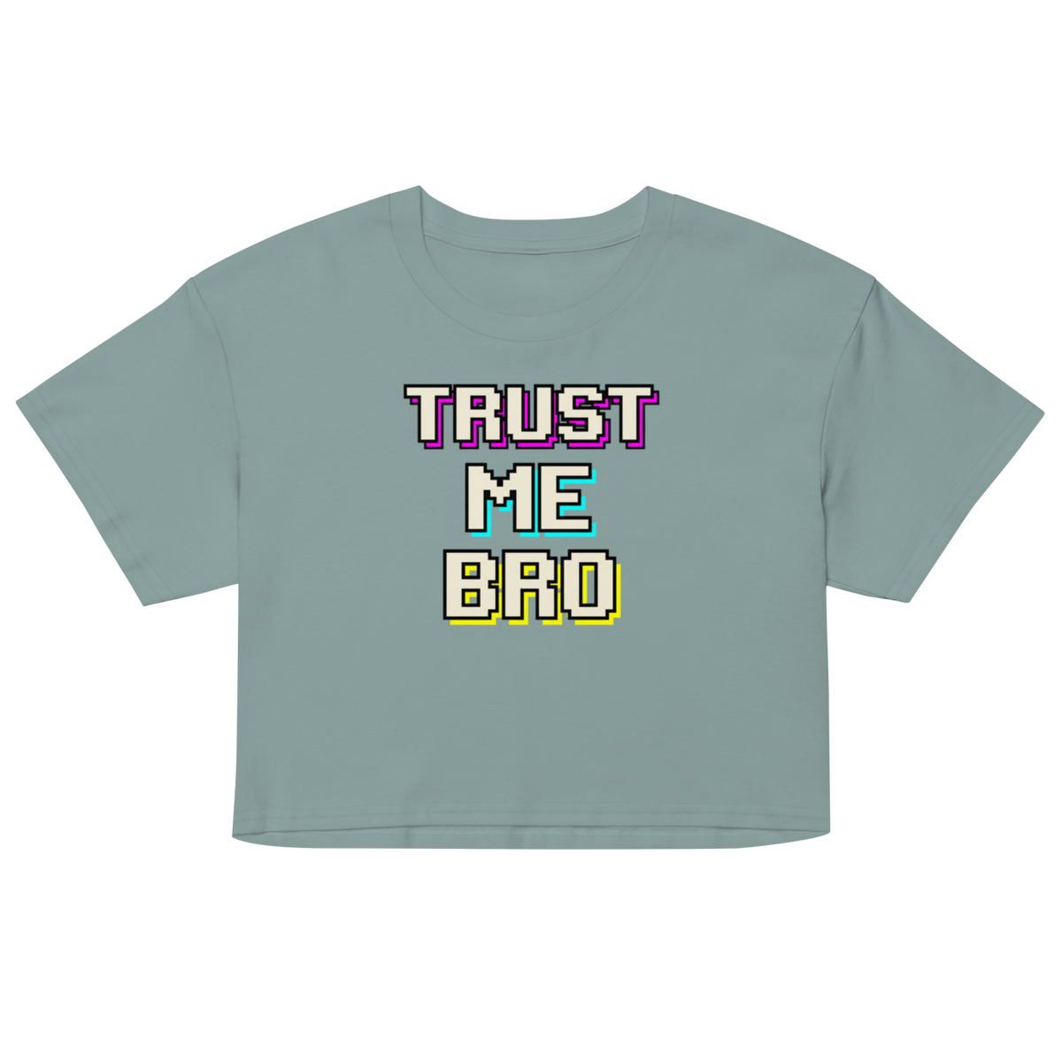 A cropped short-sleeve t-shirt in a dusty sage green color, featuring a retro pixelated graphic on the chest that reads 'TRUST ME BRO' in white, purple, light blue, and yellow.