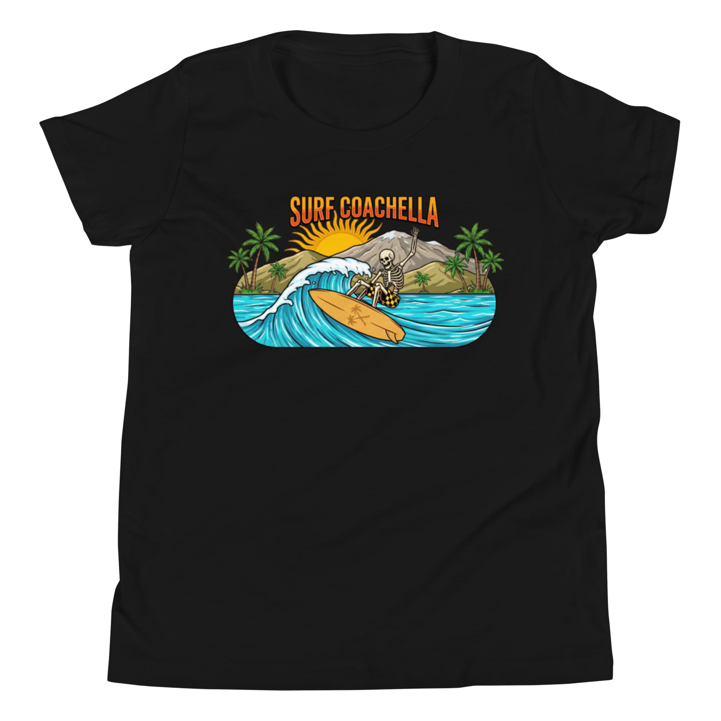 A black short-sleeve crewneck t-shirt featuring a colorful graphic print on the chest. The graphic shows a skeleton surfer riding an orange surfboard on a blue wave, with palm trees, a mountain, a rising sun, and the text 'SURF COACHELLA' in orange above.