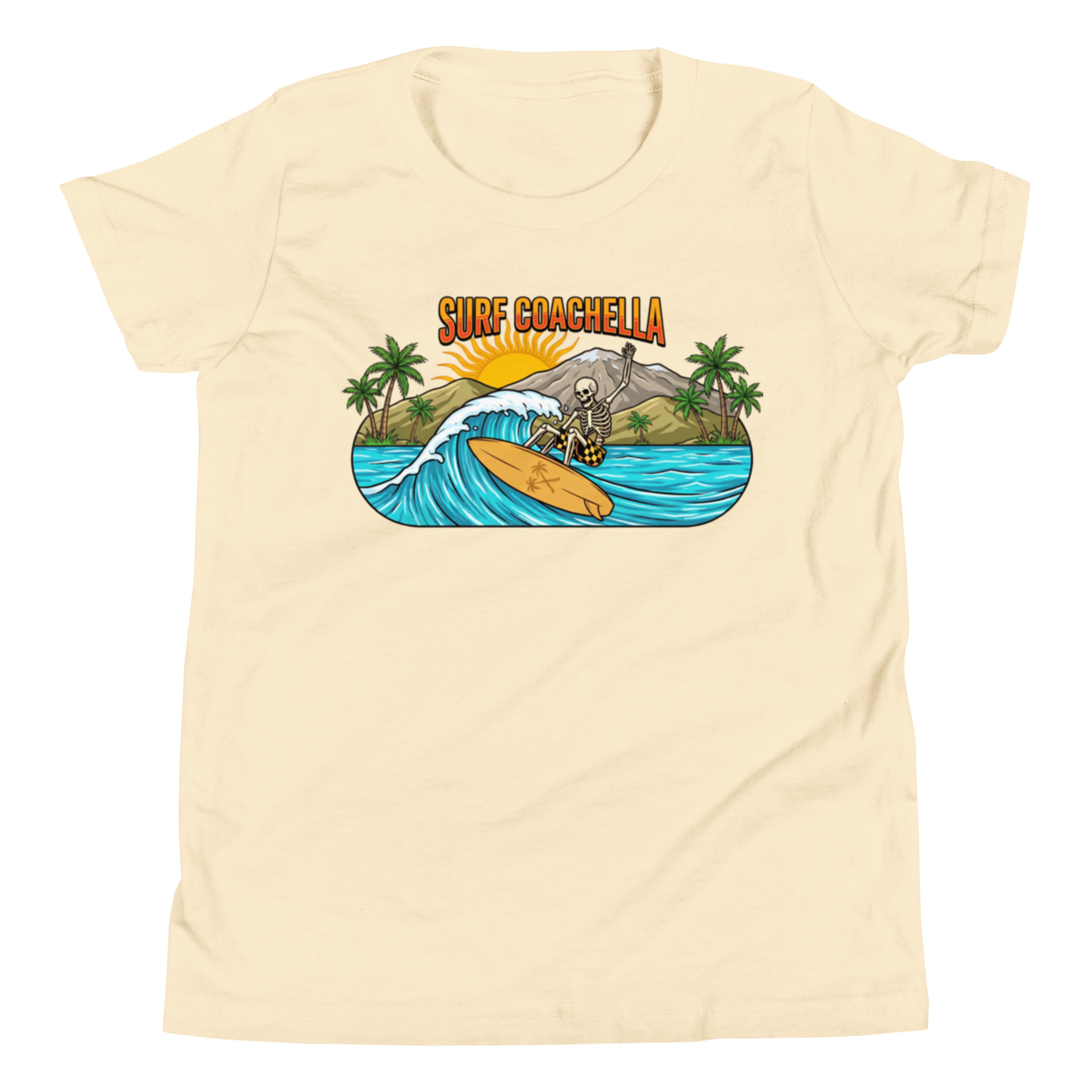 A cream-colored short-sleeve t-shirt with a colorful graphic on the chest depicting a surfer on a wave with the text 'SURF COACHELLA' above it, shown against a plain white background.